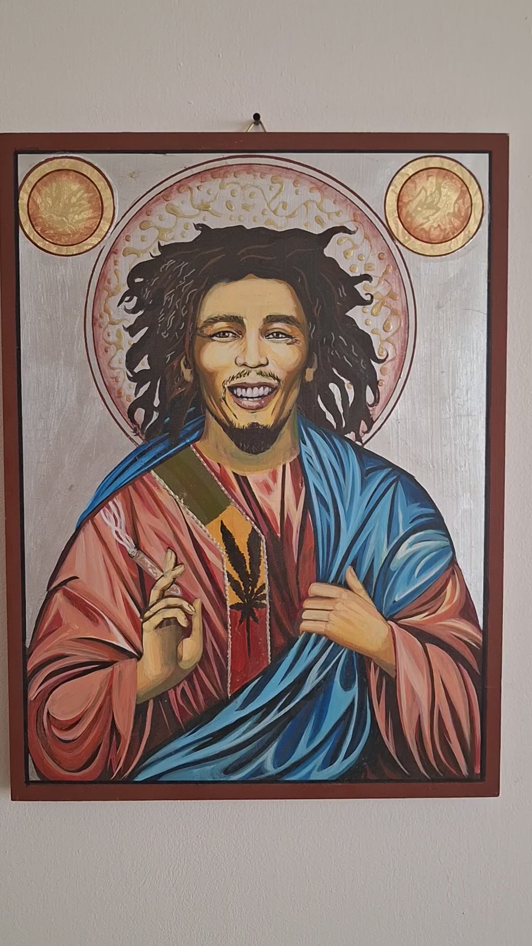 Art video showcasing a unique hand-painted anti-icon of Bob Marley, blending Rastafarian colors, spiritual symbolism, and surreal iconography, with detailed close-ups of the cracked halo, burning dreadlocks, and mystical reggae elements