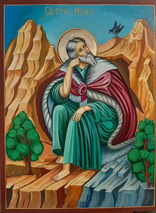 Orthodox icon of Prophet Elijah hand-painted in Byzantine style with gold leaf, seated in the desert with a raven.