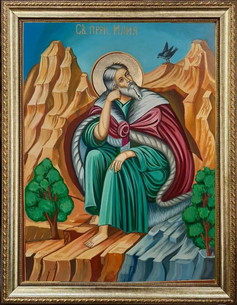 Hand-painted Orthodox Christian icon of Prophet Elijah seated in a desert landscape with a raven above, gold halo, and Byzantine-style details.