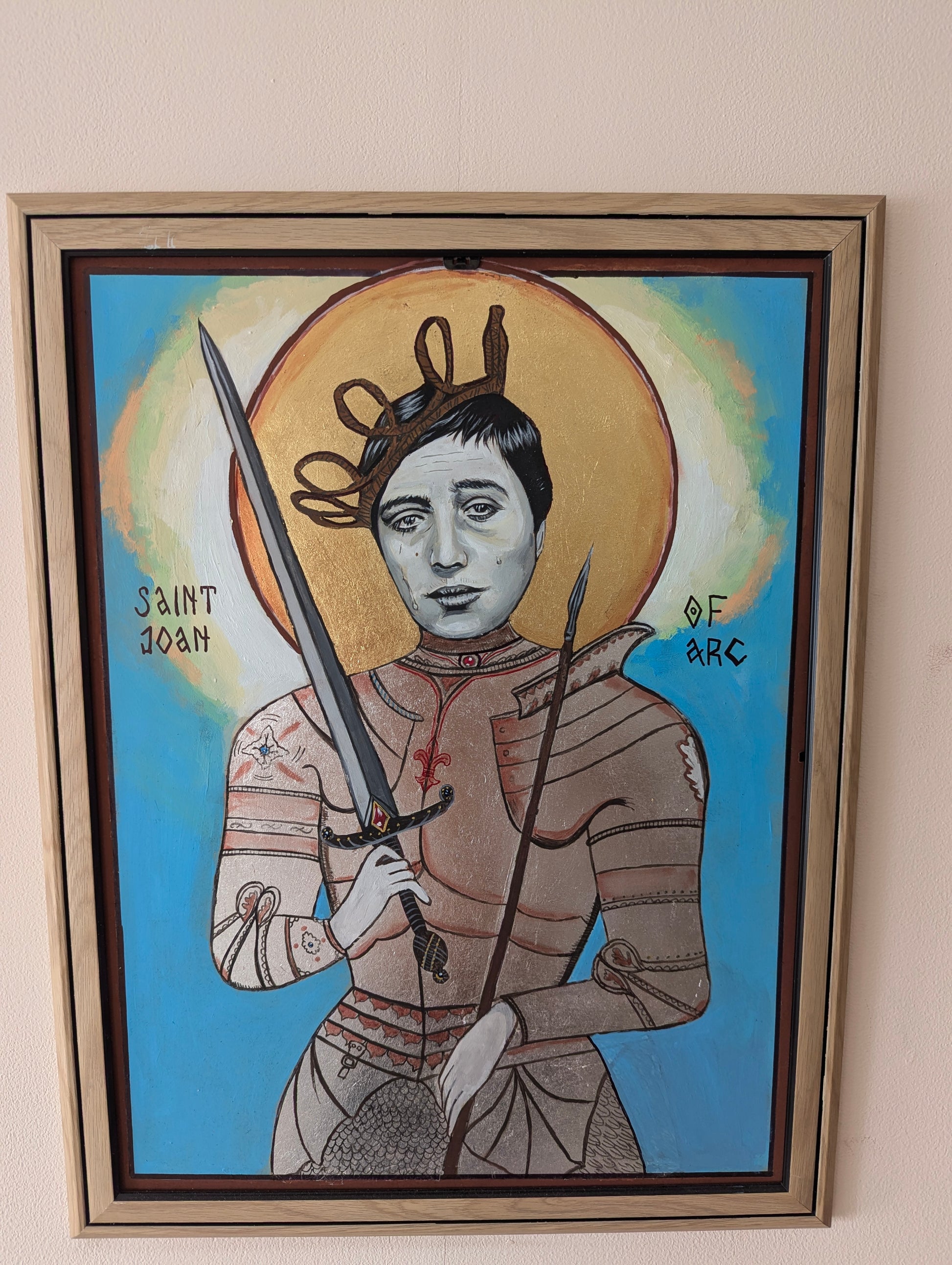 Unique religious icon of Saint Joan of Arc with sorrowful eyes, glowing gold leaf aura, sculptural silver armor, and mystical inscriptions painted in traditional style